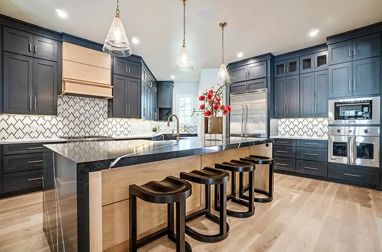 Kitchen with deep navy shaker cabinets and a black island refinished by Elegant Edge Painting.