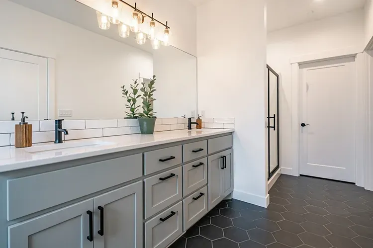 Gray-blue bathroom vanity cabinets with black pulls refinished by Elegant Edge Painting.