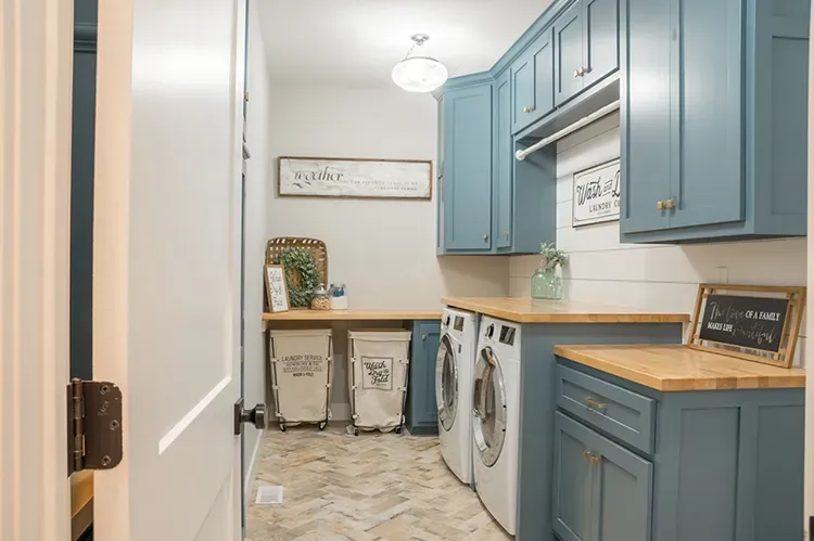 Laundry room with blue cabinets and butcher-block counters refinished by Elegant Edge Painting.