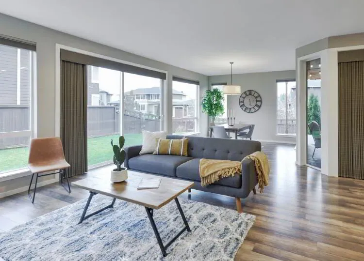 Open living room with soft gray walls and floor-to-ceiling windows after an interior repaint by Elegant Edge Painting.