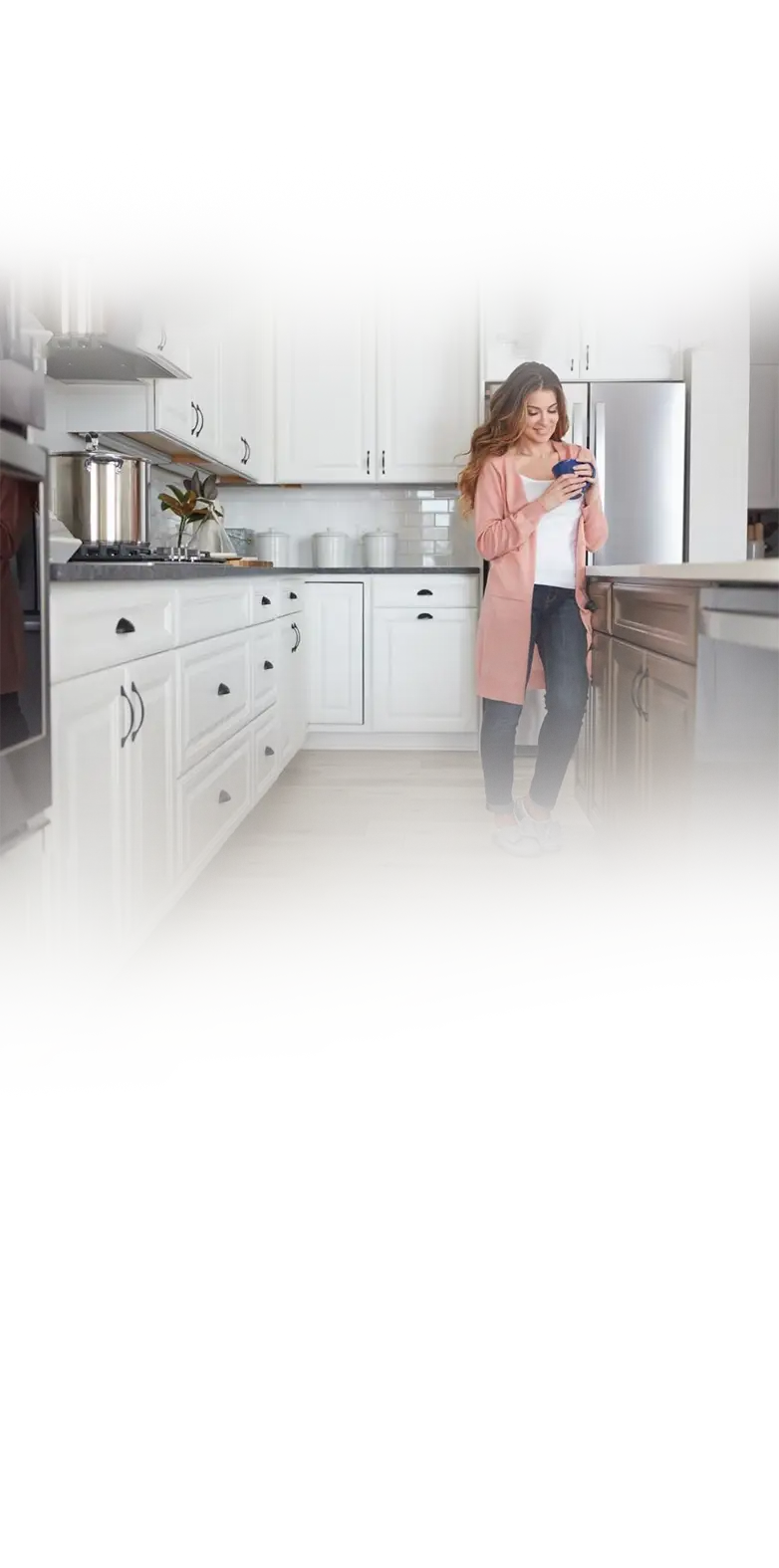A content homeowner in her kitchen with freshly painted cabinets