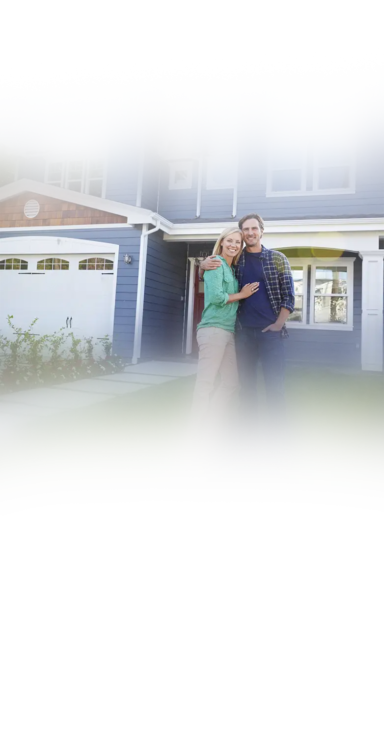 A happy homeowner couple in front of their freshly painted home
