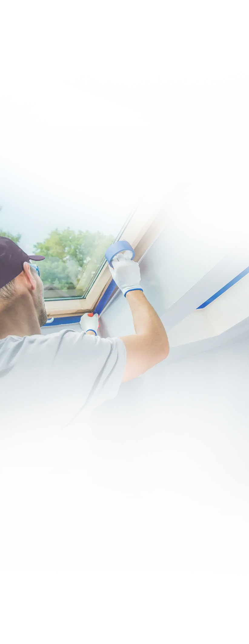 An Elegant Edge painter carefully taping a window frame before painting